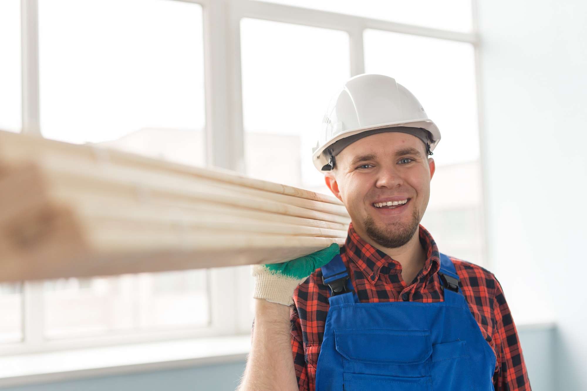 Portrait of handsome male builder laughing infront of window
